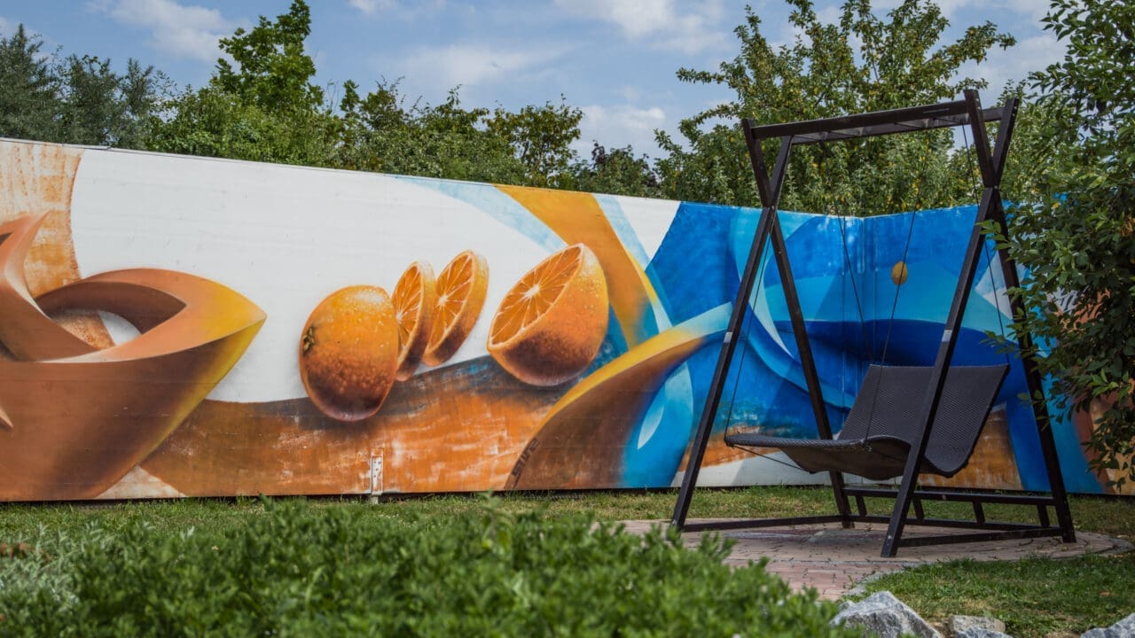 Erlebnisgarten mit Orangen-Graffiti und Schaukel