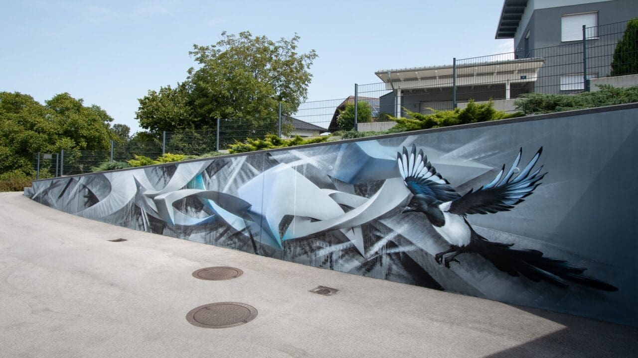 Stützmauer mit Graffiti und Elster