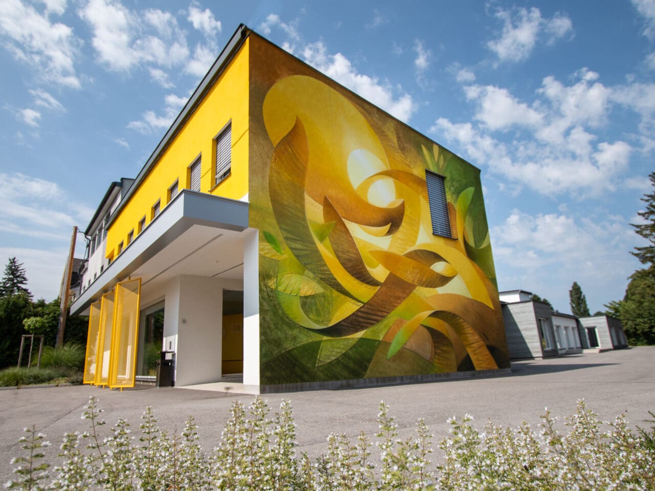 Hilfswerk Gebäude mit Wandunstwerk in gelb und grün